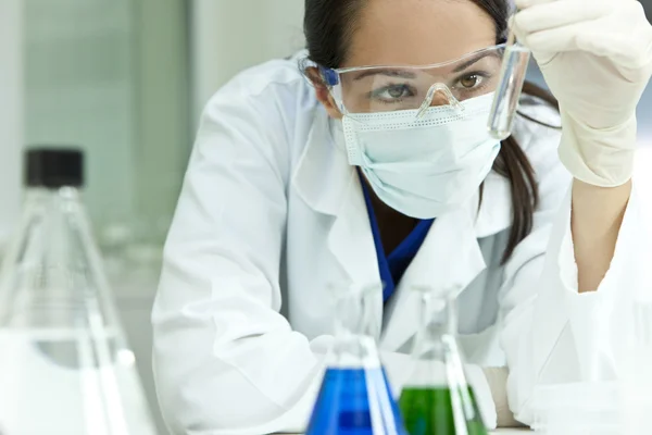 Vrouwelijke wetenschapper of vrouw arts met reageerbuis in laboratorium — Stockfoto