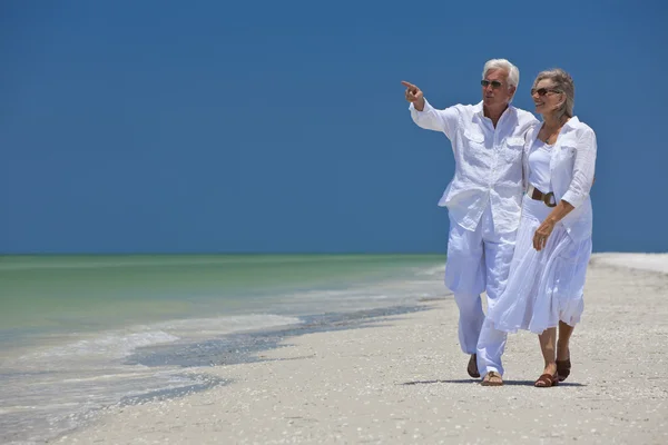 快乐的高级夫妇走海热带海滩上指向 — 图库照片