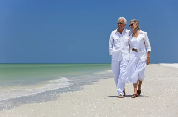 Felice coppia di anziani che cammina su una spiaggia tropicale — Foto Stock