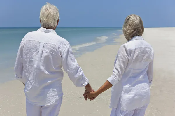 Senior Couple Holding Hands & Looking To Sea on Beach — Stock Photo, Image