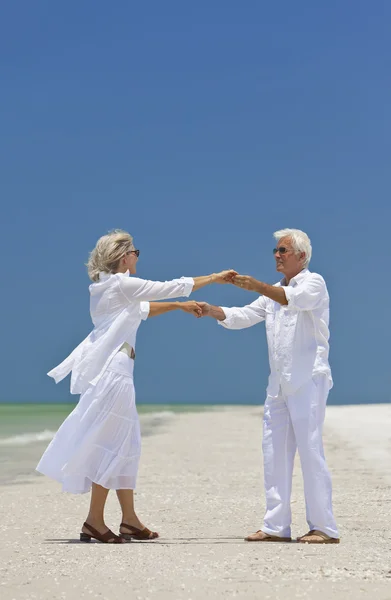 Tropik sahilde Holding dans kıdemli mutlu çift eller — Stok fotoğraf