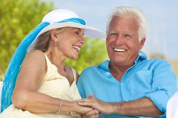 Gelukkige Senior paar bedrijf handen & lachen op het strand — Stockfoto