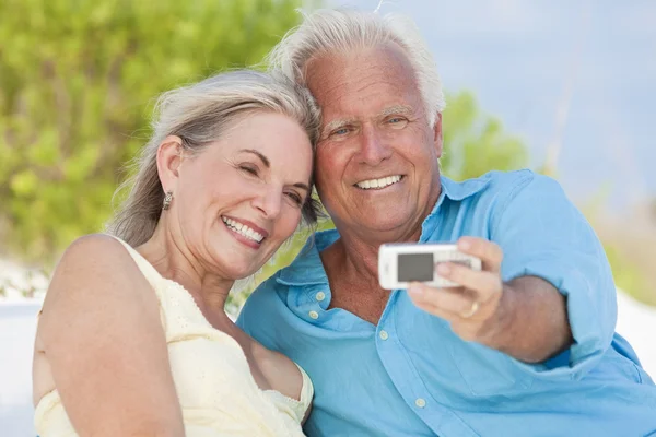 Щаслива пара старший, беручи фотографії на мобільний телефон на пляжі — стокове фото
