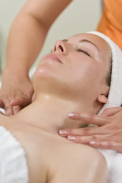Ung kvinna med ansiktsbehandling eller massage på health spa — Stockfoto