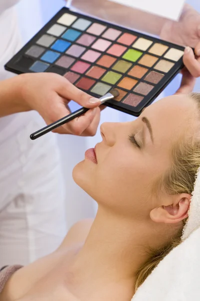 Hermosa mujer teniendo maquillaje aplicado por esteticista en el Spa —  Fotos de Stock