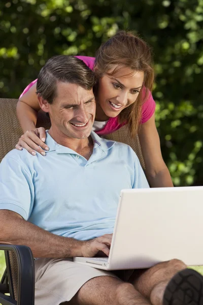 Feliz homem e mulher de meia-idade casal usando computador portátil — Fotografia de Stock