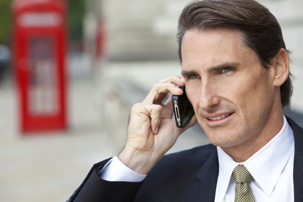 Un om de afaceri pe telefonul mobil din Londra cu o cutie telefonică roșie — Fotografie, imagine de stoc