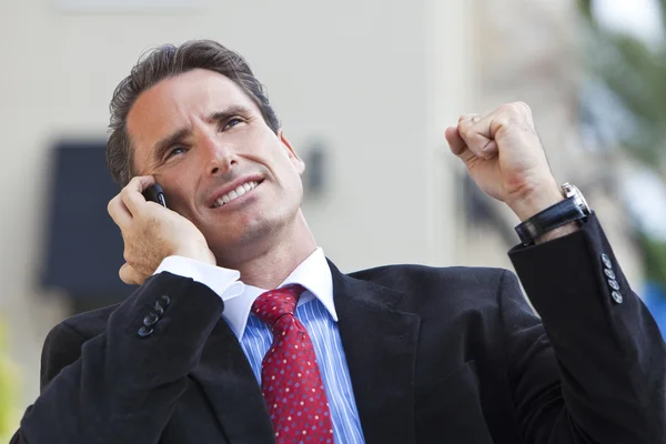Mannelijke uitvoerende zakenman vieren van succes op mobiele telefoon — Stockfoto