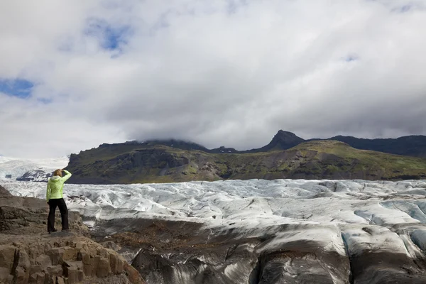 Femme randonneur regardant à travers le glacier Vatnajokull Islande — Photo