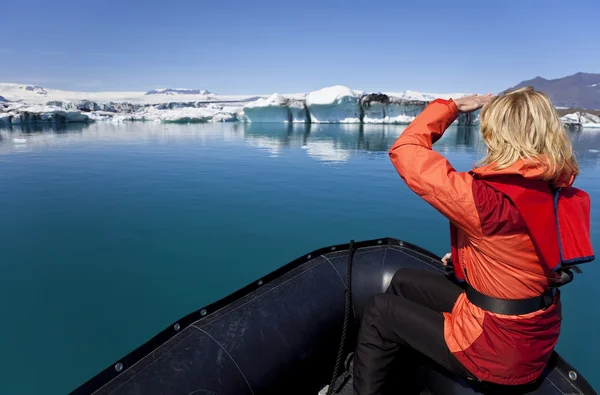 Kobieta explorer za pomocą łodzi w polu lodowej laguny jokulsarlon, — Zdjęcie stockowe