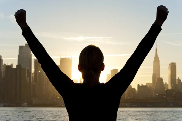 Kvinna firar upp vid soluppgången i new york city armarna — Stockfoto