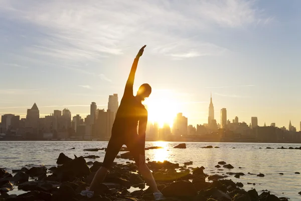 Vrouw loper yoga uitrekken manhattan skyline zonsopgang new york — Stockfoto