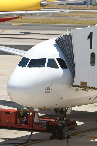 Avión en un aeropuerto con pasarela en posición — Foto de Stock