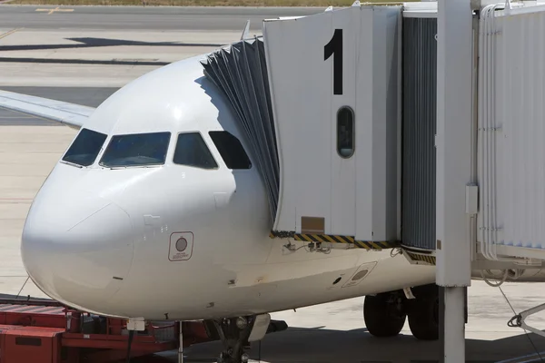 Avión en un aeropuerto con pasarela en posición —  Fotos de Stock