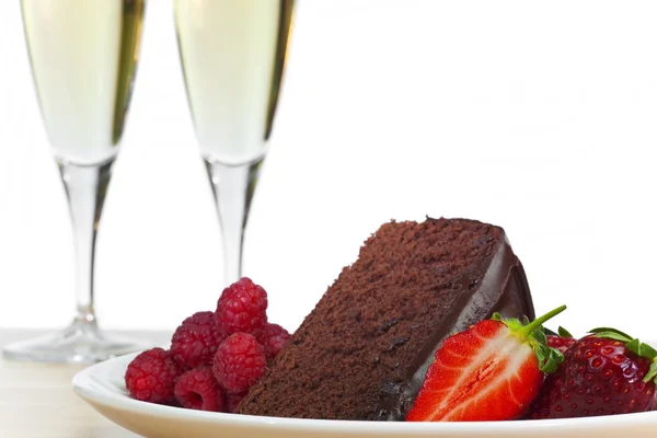 Šampaňské, čokoládový dort, maliny a jahody — Stock fotografie
