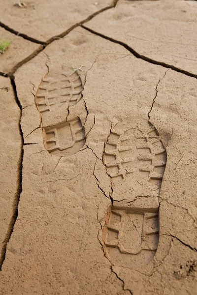 Boot Footprints in Dry Cracked Earth — Stock Photo, Image