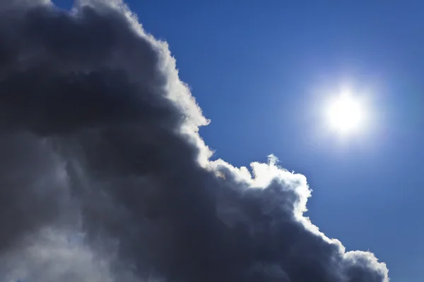 Błękitne niebo i słońce wyłania się zza chmury burzowej — Zdjęcie stockowe