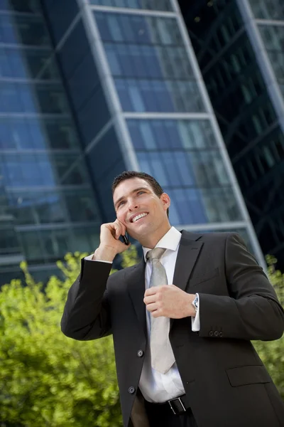 Biznesmen mówić na jego telefon komórkowy w nowoczesnym mieście — Zdjęcie stockowe