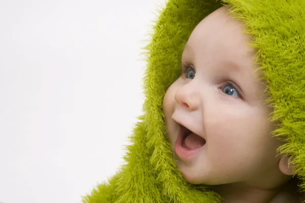 Usmívající se dítě zabalené v zelených deku nebo ručník — Stock fotografie