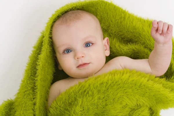 Bebé sonriente envuelto en manta verde o toalla — Foto de Stock