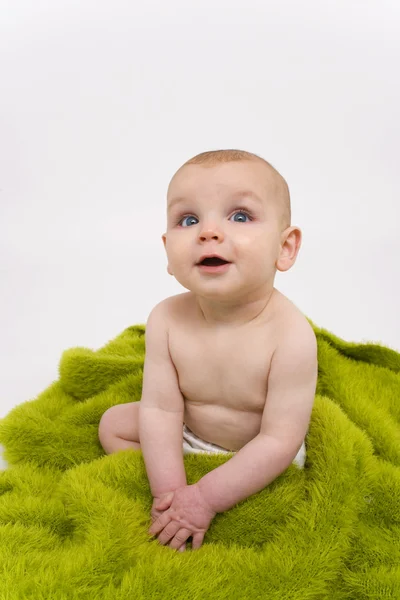 Sorrindo bebê envolto em cobertor verde ou toalha — Fotografia de Stock