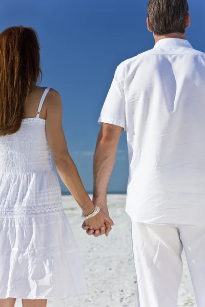 Casal segurando as mãos em uma praia vazia — Fotografia de Stock