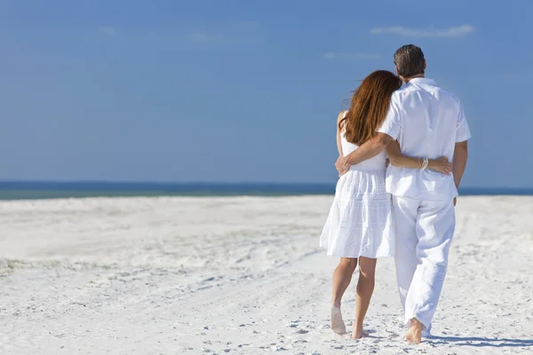 Paar spaziert an einem leeren Strand — Stockfoto