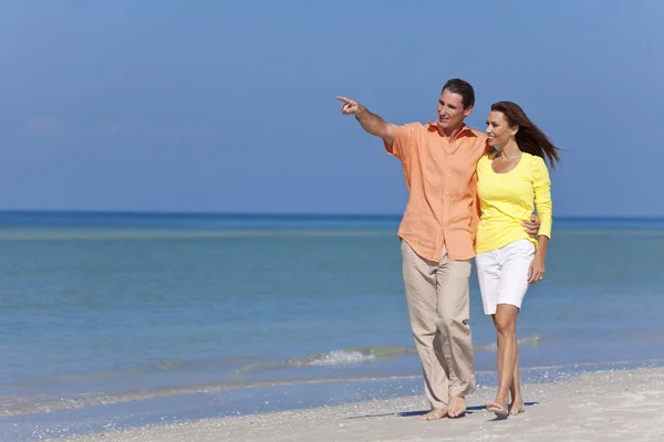 幸福的情侣散步和在海滩上指向 — 图库照片