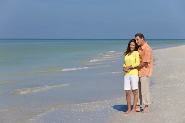 Szczęśliwy, mężczyzna i kobieta kilka ogarnięcie na pustej plaży — Zdjęcie stockowe