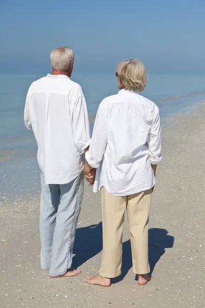 Felice coppie anziane Holdings mani su una spiaggia tropicale — Foto Stock