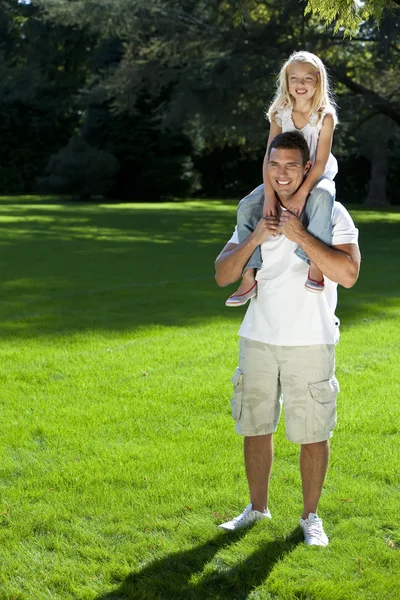 Padre con hija en hombros divirtiéndose en un parque —  Fotos de Stock