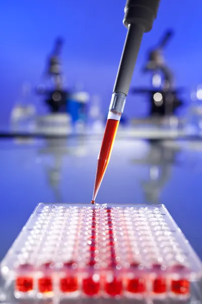 Czerwony rozwiązanie badań naukowych z pipety i płytki komórek — Zdjęcie stockowe