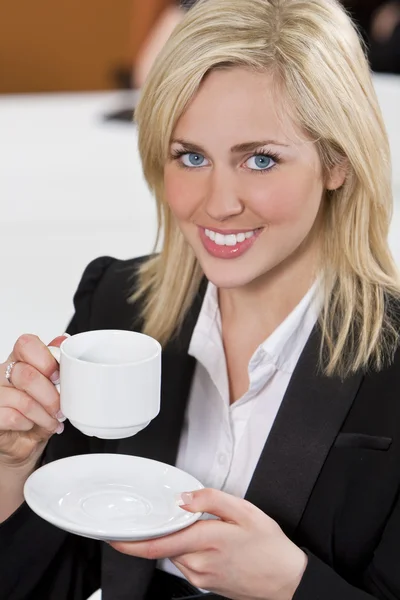Счастливая предпринимательница пьет кофе в офисе — стоковое фото