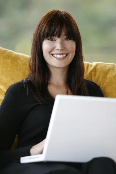 Όμορφα ευτυχισμένη γυναίκα χρησιμοποιώντας φορητό υπολογιστή στο σπίτι — Φωτογραφία Αρχείου