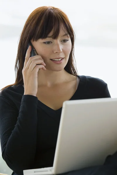 Vacker glad kvinna med bärbar dator och telefon i hom — Stockfoto