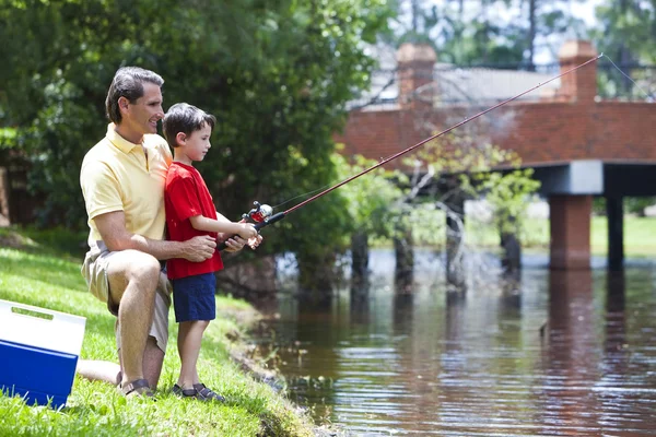 Отец рыбачит со своим сыном на причале — стоковое фото