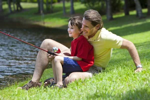 Vader vissen met zijn zoon aan een rivier — Stockfoto