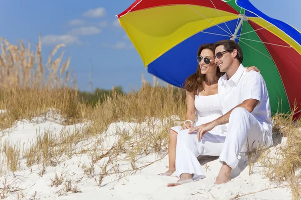 Man & kvinna par Under färgglada paraply på stranden — Stockfoto