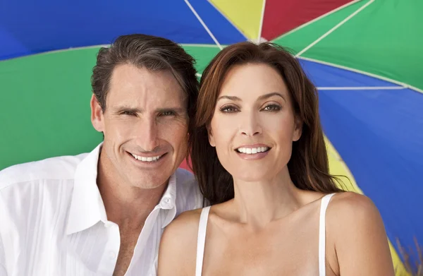 Uomo & Donna Coppia Sotto Multi Ombrello Colorato sulla Spiaggia — Foto Stock