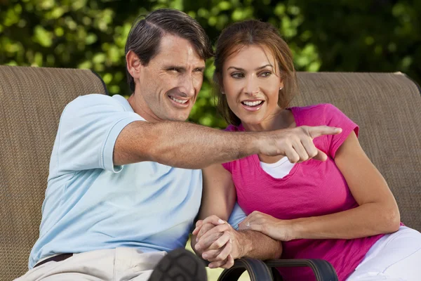 Feliz hombre de mediana edad mujer pareja sosteniendo las manos y señalando —  Fotos de Stock