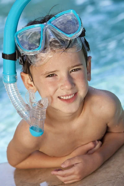 Gelukkige jongen in een zwembad met bril en snorkel — Stockfoto