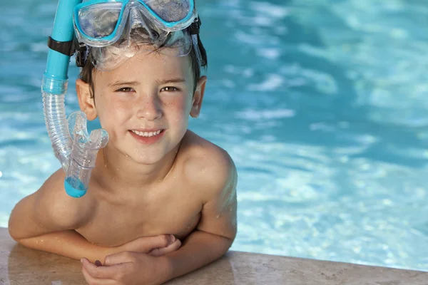 Rapaz feliz na piscina com óculos azuis e snorkel — Fotografia de Stock
