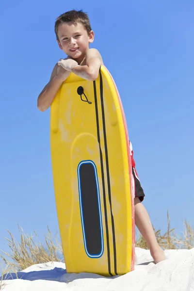 Ung pojke barn med surfbräda på stranden — Stockfoto