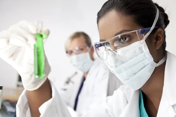 Aziatische vrouwelijke wetenschapper met laboratorium reageerbuis van groene soluti — Stockfoto