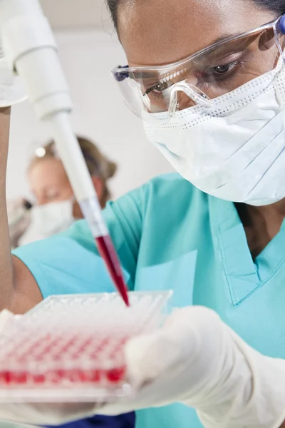 Asijské ženské vědec pomocí pipety a krve v laborat — Stock fotografie
