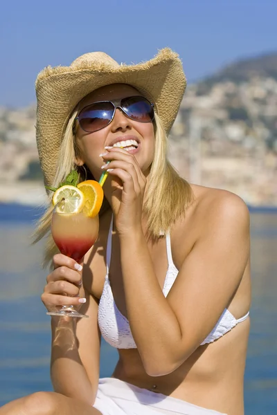 Hermosa chica rubia en bikini de beber cóctel junto al mar — Stockfoto