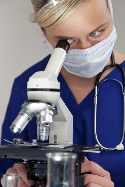 Cientista ou médica mulher usando microscópio em um laboratório — Fotografia de Stock
