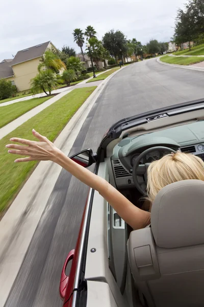 Mujer joven conduciendo coche convertible con la mano en el aire — Foto de Stock