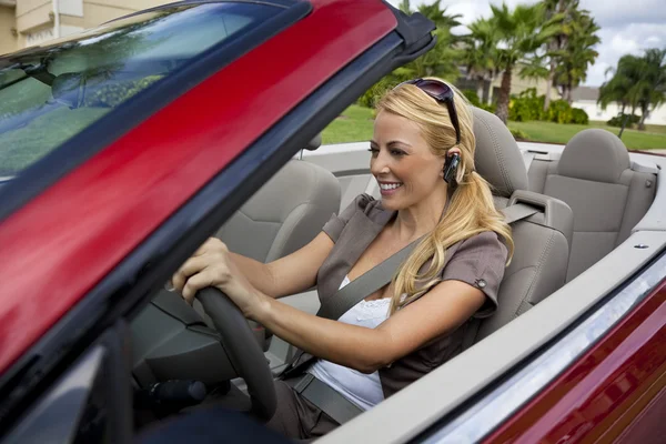 Mooie jonge vrouw rijden converteerbare auto praten over bluetoo — Stockfoto