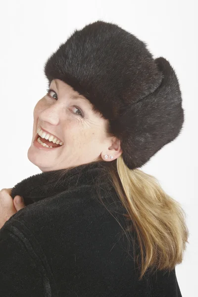 Sarışın bir kadın Rus tarzı kürk şapka ve paltosunu giyiyor — Stok fotoğraf